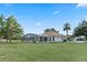 Large backyard featuring a screen enclosed lanai, mature trees, and a well-kept lawn at 1441 Olde Kensington Ln, Deltona, FL 32725