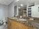 Bathroom featuring double sinks with granite countertop, a spacious mirror, and a walk-in shower at 155 S Court Ave # 1305, Orlando, FL 32801