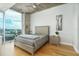Bright modern bedroom features a large window with city view, a comfortable bed, and sleek nightstands at 155 S Court Ave # 1305, Orlando, FL 32801