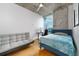 Cozy bedroom features a modern design, concrete ceiling, large window with city views, and comfortable furnishings at 155 S Court Ave # 1305, Orlando, FL 32801