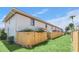 Exterior view of backyard features a privacy fence, lush green lawn, and well-maintained landscaping at 1612 Sandy Point Sq # 56, Orlando, FL 32807