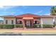 Charming brick clubhouse with an arched entryway, manicured hedges, and a red tile roof creating a welcoming first impression at 1612 Sandy Point Sq # 56, Orlando, FL 32807