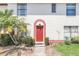 Inviting front entrance with a red door, lush landscaping, and well-maintained surroundings at 1612 Sandy Point Sq # 56, Orlando, FL 32807