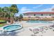 Relax in the hot tub or lounge poolside on provided seating, complemented by lush palms offering a serene and comfortable escape at 1612 Sandy Point Sq # 56, Orlando, FL 32807