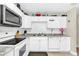 Efficient kitchen with white cabinets, a stainless steel microwave, and tile countertops at 1612 Sandy Point Sq # 56, Orlando, FL 32807