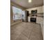 Modern kitchen with stainless steel appliances and large tile flooring, plus ample natural light at 1612 Sandy Point Sq # 56, Orlando, FL 32807