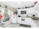 Functional kitchen featuring white cabinets, tile floors and countertops, and essential appliances at 1612 Sandy Point Sq # 56, Orlando, FL 32807