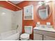 Bathroom includes a shower over tub, toilet, and sink with mirrored wall cabinet at 17 W Nightingale St, Apopka, FL 32712