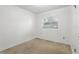 Small bedroom with a window and white walls, featuring beige carpeting at 17 W Nightingale St, Apopka, FL 32712
