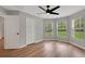 Bright bedroom features wood floors, a ceiling fan, closet, and natural light from multiple windows at 1861 E Glancy Dr, Deltona, FL 32725