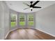 Bedroom with wood floors, ceiling fan, and natural light from large windows overlooking the backyard at 1861 E Glancy Dr, Deltona, FL 32725