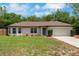 Charming single-story home with manicured lawn, bay window, mature landscaping, and two-car garage at 1861 E Glancy Dr, Deltona, FL 32725