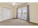 Bedroom features a ceiling fan, carpet floors, and a set of french doors leading to a porch overlooking the water at 2384 John Anderson Dr, Ormond Beach, FL 32176