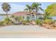 Inviting waterfront home featuring lush landscaping, mature palm trees, and a serene coastal setting at 2384 John Anderson Dr, Ormond Beach, FL 32176