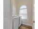Bright laundry room featuring a front loading washer and dryer, wood-look floors, and a window with natural light at 2384 John Anderson Dr, Ormond Beach, FL 32176