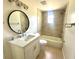 Updated bathroom with quartz countertop, round mirror, and tiled shower/tub combo at 2514 Highlawn Ave, Sanford, FL 32773