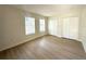 Bright bedroom with hardwood floors, multiple windows, and white closet doors at 2514 Highlawn Ave, Sanford, FL 32773