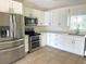 Modern kitchen with stainless steel appliances, white cabinetry, and neutral countertops at 2514 Highlawn Ave, Sanford, FL 32773