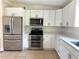 Modern kitchen features stainless steel appliances, white cabinets, and tile flooring at 2514 Highlawn Ave, Sanford, FL 32773