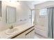 Bright bathroom with a decorative mirror, spacious countertop, and tiled shower and tub at 262 W Sabal Palm Pl, Longwood, FL 32779