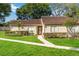 Single-story home with a well-kept lawn, trimmed hedges and brown roof at 262 W Sabal Palm Pl, Longwood, FL 32779