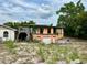 Two story house with overgrown vines, a garage, and a ground-level entrance at 300 Broadview Ave, Altamonte Springs, FL 32701
