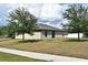 A sunny backyard features a well-maintained lawn and mature trees, offering privacy at 35734 Rose Moss Ave, Leesburg, FL 34788