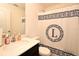 Bathroom with a black vanity cabinet, white sink and countertop, and a toilet behind a decorative shower curtain at 35734 Rose Moss Ave, Leesburg, FL 34788