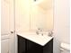 Bathroom with a dark vanity cabinet, modern white sink and light countertops, and a large mirror at 35734 Rose Moss Ave, Leesburg, FL 34788