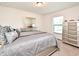 Bedroom with a queen-sized bed, large windows with blinds, and silver nightstands and drawers at 35734 Rose Moss Ave, Leesburg, FL 34788