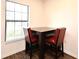 Quaint dining area features square dark wood table and upholstered dining chairs near a bright window at 35734 Rose Moss Ave, Leesburg, FL 34788