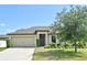 Charming single-story home featuring a well-maintained lawn, inviting entrance, and two-car garage at 35734 Rose Moss Ave, Leesburg, FL 34788