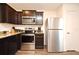 Well-equipped kitchen featuring stainless steel appliances, dark wood cabinets and granite countertops at 35734 Rose Moss Ave, Leesburg, FL 34788