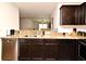 Kitchen sink with granite countertops, stainless steel dishwasher and dark wood cabinets at 35734 Rose Moss Ave, Leesburg, FL 34788
