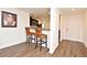 Cozy kitchenette features wood-look floors and breakfast bar with two flower-patterned upholstered bar stools at 35734 Rose Moss Ave, Leesburg, FL 34788