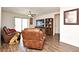 Spacious living room features laminate flooring, ceiling fan and brown leather furniture set at 35734 Rose Moss Ave, Leesburg, FL 34788