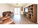 Inviting living space with wood-look floors, large sliding glass door, and modern furnishings at 35734 Rose Moss Ave, Leesburg, FL 34788
