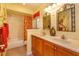 Bathroom featuring double sinks, framed mirrors, shower and tub combo, and vanity with red accents at 413 Sandy Hill Dr, Longwood, FL 32779