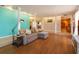 Spacious living room with wood floors, turquoise accent wall, and modern lighting at 413 Sandy Hill Dr, Longwood, FL 32779