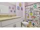 Whimsical bathroom featuring a unicorn-themed shower curtain, pink walls, and a granite-topped vanity at 415 Anne St, Deland, FL 32724