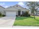 Charming single-story home with a well-maintained lawn and attached two-car garage at 415 Anne St, Deland, FL 32724
