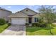 Charming single-story home featuring a well-maintained lawn, a two-car garage, and a welcoming front entrance at 415 Anne St, Deland, FL 32724