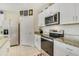 Granite counters, stainless appliances, and white cabinets accent this bright kitchen at 415 Anne St, Deland, FL 32724