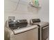 Modern laundry room with front-load washer and dryer and storage shelving at 415 Anne St, Deland, FL 32724