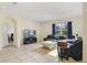 Cozy living room with tiled floor, large window with blue curtains, and comfortable seating at 415 Anne St, Deland, FL 32724
