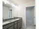 Bathroom with double sinks, granite countertop, modern lighting, and a view of the shower and toilet at 4185 Sagefield Dr, St Cloud, FL 34773