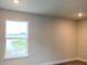 Bedroom with tan walls, carpeted floors, and a window with a view of a pond at 4185 Sagefield Dr, St Cloud, FL 34773