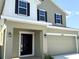 Two-story home with a front-facing garage and black shutters, and neutral colored paint at 4185 Sagefield Dr, St Cloud, FL 34773