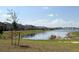 Scenic view of a tranquil pond surrounded by lush green grass and neighborhood homes at 4185 Sagefield Dr, St Cloud, FL 34773