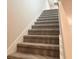 Carpeted staircase featuring neutral colored carpet and white risers and stringers at 4185 Sagefield Dr, St Cloud, FL 34773